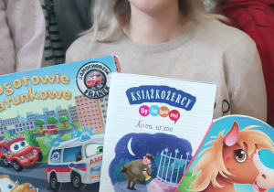 Pani pokazuje książki, które przeczytała dzieciom.