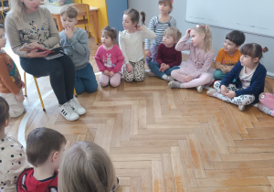 Pani czyta dzieciom książkę i pokazuje ilustrację.
