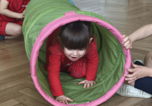 Dzieci wykonują ćwiczenie z tunelem