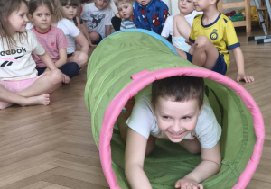 Dzieci wykonują ćwiczenie z tunelem