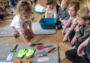 dziewczynka kładzie łopatkę na dywaniku