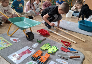 chłopiec patrzy na grabie