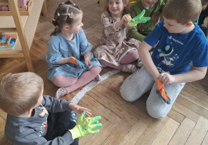 dzieci przymierzają ogrodowe rękawiczki
