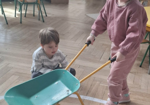 dzieczynka trzyma taczkę