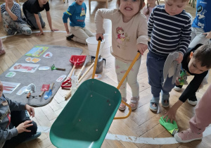 dzieczynka trzyma taczkę