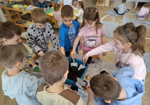 dzieci nabierają ziemię z pojemnika