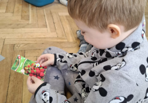 chłopiec trzyma w ręku opakowanie z nasionami roślin