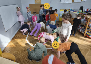 Na zdjęciu widzimy grupkę dzieci, które uczestniczą w zabawie ruchowej, której celem jest naśladowanie wymienionych zwierząt egzotycznych.