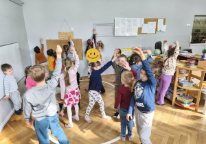 Na zdjęciu widzimy grupkę dzieci, które uczestniczą w zabawie ruchowej, której celem jest naśladowanie wymienionych zwierząt egzotycznych.