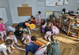 Na zdjęciu widzimy grupkę dzieci, które uczestniczą w zabawie ruchowej, której celem jest naśladowanie wymienionych zwierząt egzotycznych.