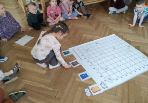 dziewczynka odkłada śmieci do odpowiedniego pojemnika