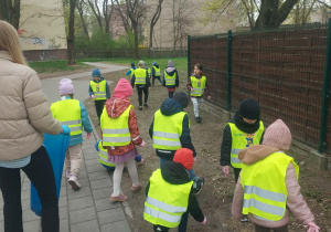 Dzieci zbierają śmieci wokół przedszkola