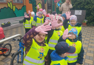 Wyposażone dzieci w rękawiczki idziemy sprzątać wokół przedszkola