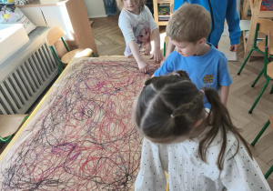 Dzieci uczestniczą w zabawie Edukacji przez ruch - malując spirale i owale