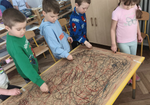 Dzieci uczestniczą w zabawie Edukacji przez ruch - malując spirale i owale