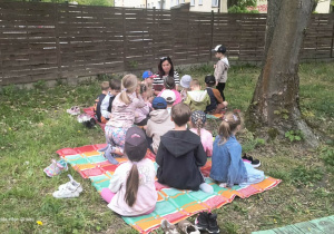 Dzieci z nauczycielem podczas czytania książki " Gdy dorosnę zostanę strażakiem"