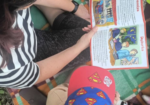 Dzieci z nauczycielem podczas czytania książki " Gdy dorosnę zostanę strażakiem"