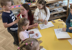 Dzieci kolorują rozmawiając z mama Grzesia