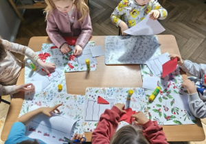 Na zdjęciu widzimy dzieci, które wykonują pracę plastyczną metodą wydzieranki.