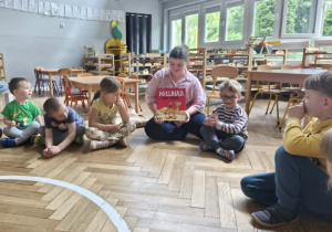 Na zdjęciu widzimy mamę Viktora, która pokazuje dzieciom książkę którą będzie czytać.