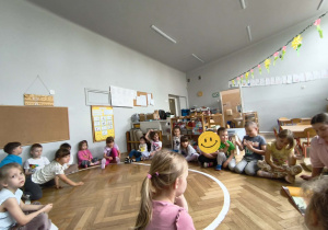 Na zdjęciu widzimy dzieci, które słuchają czytanej książki.