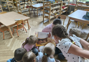 Na zdjęciu widzimy dzieci, które oglądają ilustracje z książki.