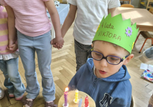 Na zdjęciu widzimy Jubilata zdmuchującego świeczki na torcie.