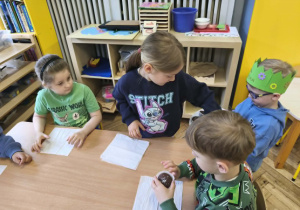 Na zdjęciu widzimy Jubilata, który częstuje dzieci babeczkami.