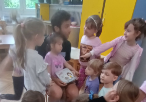Tata czyta dzieciom książkę.