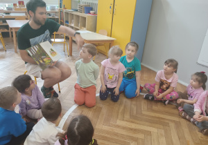 Tata czyta dzieciom książkę.
