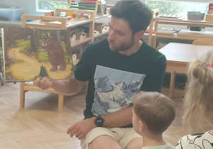 Tata czyta dzieciom książkę.