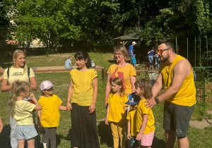 Zdjęcie przedstawia rodziców i dzieci w żółtych koszulkach.