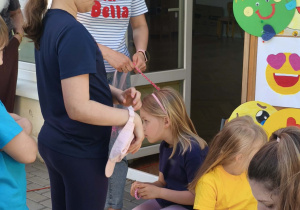 Zdjęcie przedstawia dziecko czekające na pomalowanie twarzy.