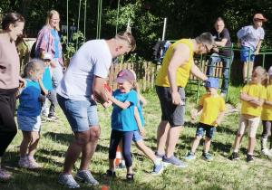 Zdjęcie przedstawia dzieci i rodziców biorących udział w konkurencji.