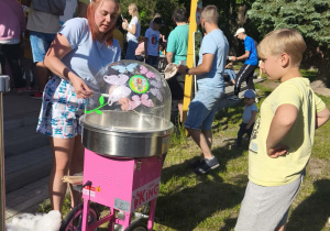 Zdjęcie przedstawia chłopca czekającego na watę cukrową.