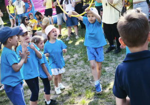 Zdjęcie przedstawia dzieci biorące udział w konkurencji z hula hop.