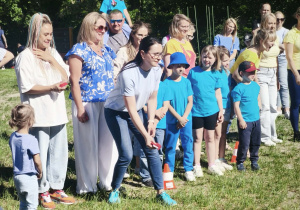 Zdjęcie przedstawia mamy rzucające woreczkami. Reszta uczestników stoi obok.