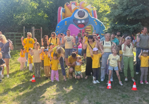 Zdjęcie przedstawia grupę ludzi ubranych na żółto, którzy biorą udział w zabawie ruchowej.