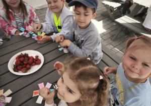 Dzieci jedzą lody z truskawkami