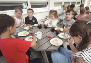 Dzieci jedzą obiad na tarasie