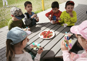 Dzieci jedzą lody z truskawkami