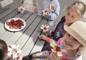 Dzieci jedzą lody z truskawkami