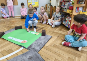Na zdjęciu widzimy chłopca, który przyporządkowuje kartkę ze zdaniem do odpowiedniego znaczka.