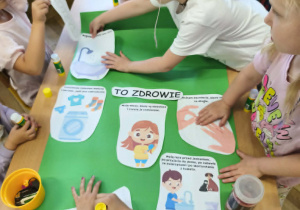 Na zdjęciu widzimy grupkę dzieci, które tworzą plakat "Czystość to zdrowie".