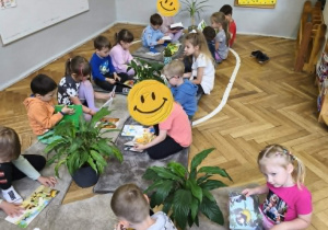 Na zdjęciu widzimy dzieci, które oglądają książki.