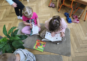 Na zdjęciu widzimy dzieci, które oglądają książki.