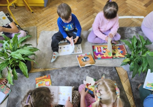 Na zdjęciu widzimy dzieci, które oglądają książki.