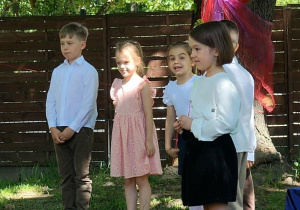 Zdjęcie przedstawia kilkoro dzieci podczas występu.