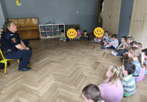 Na zdjęciu widzimy grupkę dzieci, które słuchają Pań funkcjonariuszek ze Straży Miejskiej.
