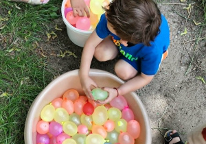 chłopiec biorący balony z miski
